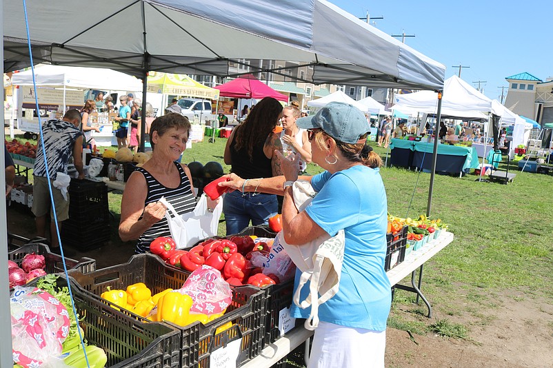 Karen Haugh, right, places a red pepper in a bag held by Linda Baker at the Al's Produce stand.