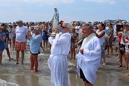 Shown at the water’s edge during the 2021 celebration are Deacon Joseph Murphy (holding statue) and Rev. Perry Cherubini. (Photo courtesy of Sea Isle City)