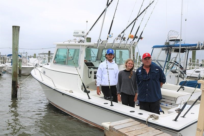 Michael Doebley, right, stands on his 28-foot Steiger Craft with crew members Colby Felix and Logan Monteleone.