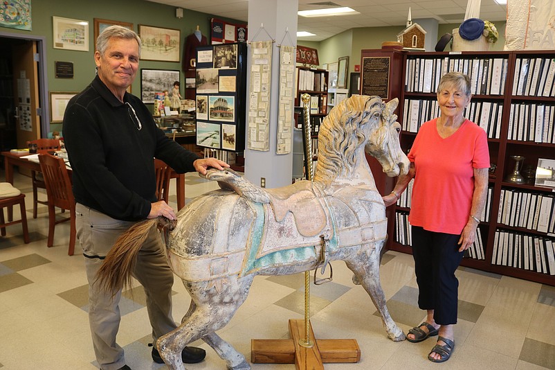 Museum President Ron Kovatis and volunteer Claire McGough marvel over the beauty of the carousel horse.