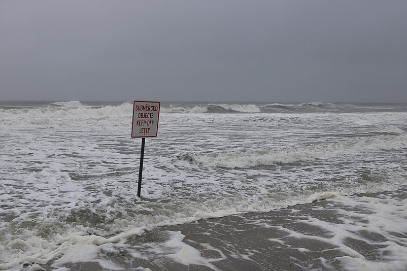 Stong waves pummel a sign during the remnants of Hurricane Ian.