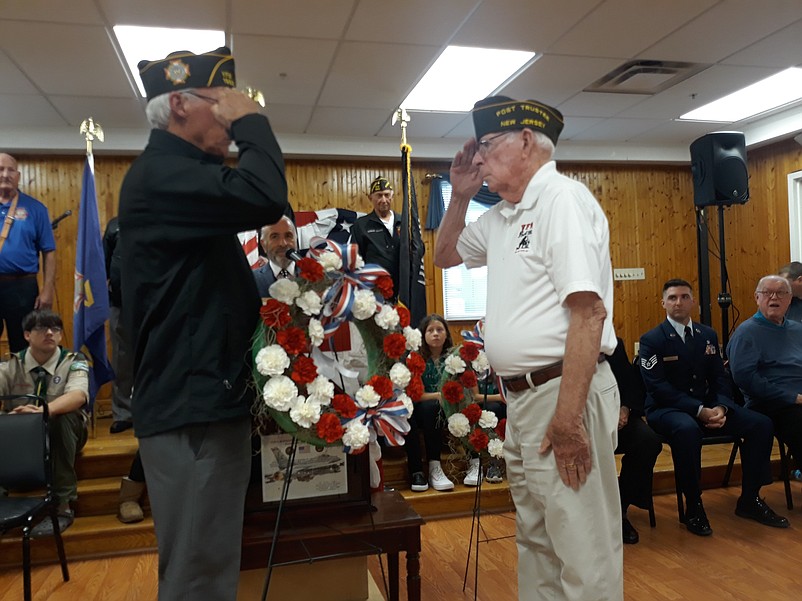 VFW Post 1963 Commander Mark Lloyd, left, salutes fellow veteran Frank Diamond during the ceremonial laying of a wreath.