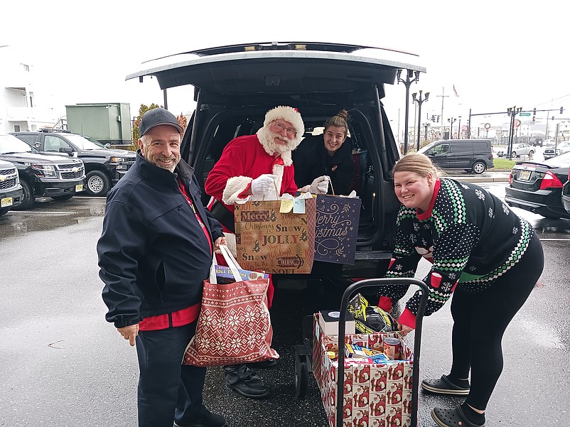 Mayor Leonard Desiderio, left, is joined by Santa and some of his "elves" while loading gifts for families in need during the 2022 Holiday Toy and Food Drive.