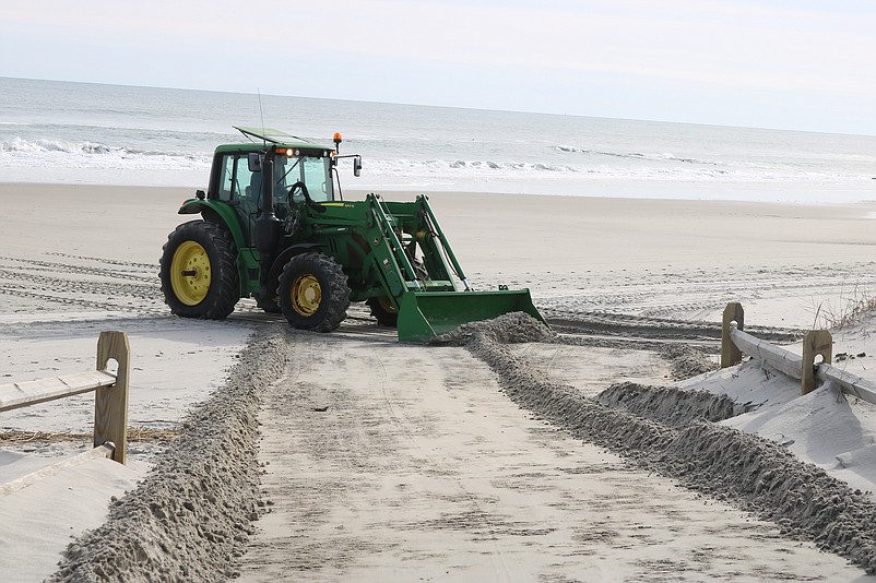 A Public Works employee uses a front-end loader to level off the beach pathway at 39th Street in February 2023 after a storm caused erosion.