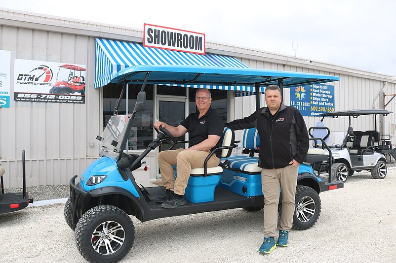 Arret Dobson and Mark Boyle, at the wheel, show off an electric cart available for sale at their new DTM Powersports location in Marmora.