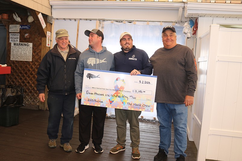 Hank Sauce co-owners Hank Ruxton and Matt Pittaluga are flanked by Mike Givens and Mike Monichetti, co-founders of the Mike's Seafood Run-Walk for Autism, during the check presentation ceremony.