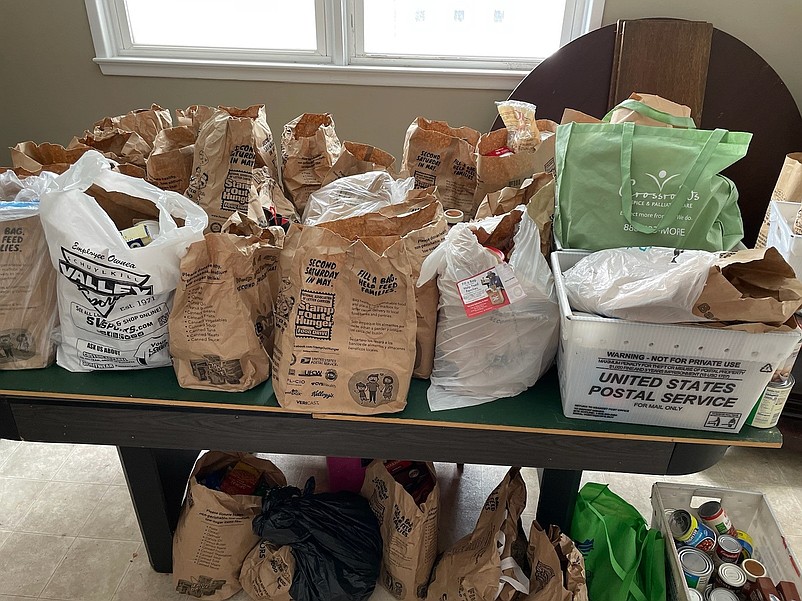 Food donations collected by postal workers line the tables in the food cupboard at the church. (Photo courtesy of Pastor Melissa Doyle-Waid)