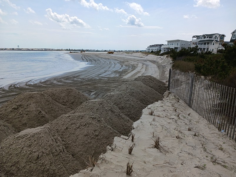 Huge piles of sand are being placed along the shoreline to fortify the eroded dunes in the southern end of Sea Isle when work began in May.