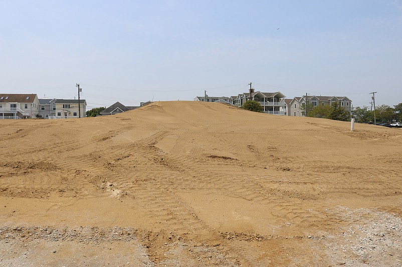 A massive pile of soil at the construction site is undergoing a process known as "surcharging."