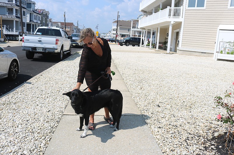 Trish Zecca, a Sea Isle vacationer, gives her dog, Rosie, an affectionate pat on the head during a walk along Sounds Avenue.