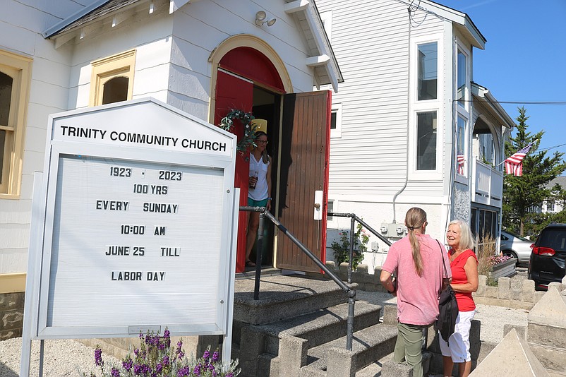 A sign next to the front steps notes that Trinity is celebrating its 100th anniversary.