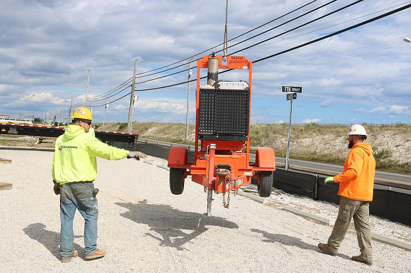 Schiavone Construction workers Daniel Dunn, left, and Vince DiVentura  handle some of the equipment that will be used to build the dog park.