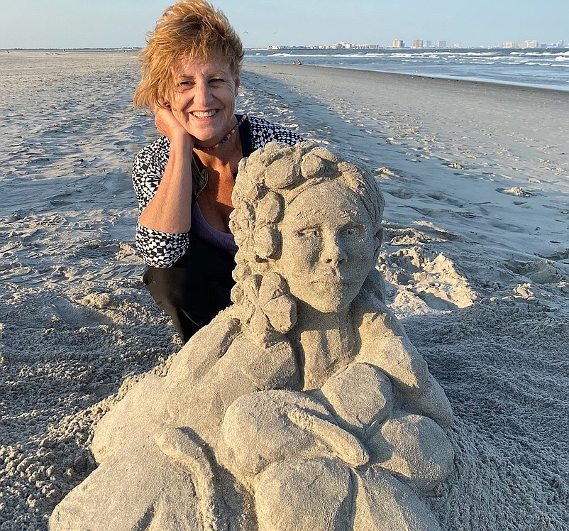 Kathy Nichols kneels next to a sculpture she made on the beach in the north end of Ocean City over the summer. (Photos courtesy of Kathy Nichols)