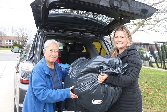 Rissa Trofa, left, of the Ocean City Ecumenical Council, and realtor Lauren Crowley carry a bag of donated clothing into the Clothes Closet.