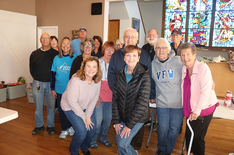 Volunteers join Pastor Melissa Doyle Waid, in front at left, for a group photo after helping out with the food.