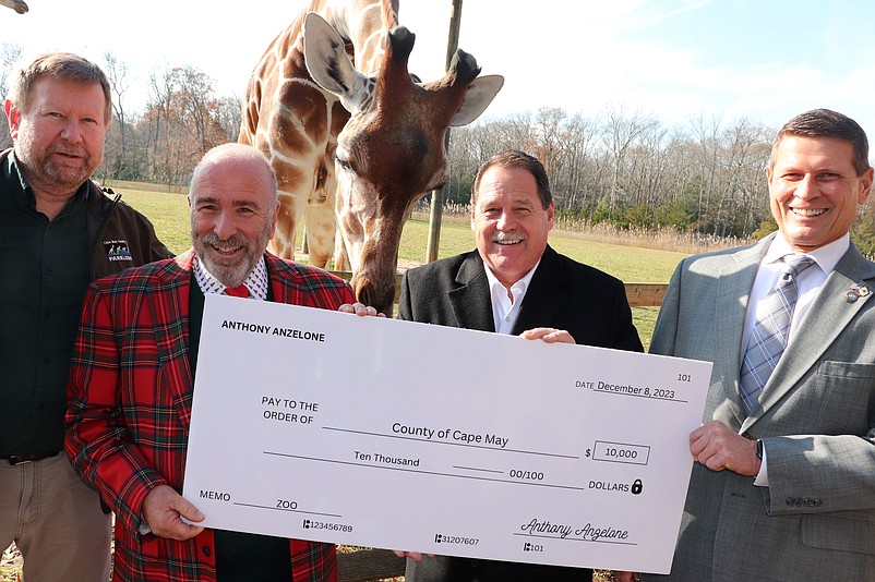 Anthony Anzelone, second from right, presents his donation to Parks Director Edward Runyon and Cape May County Commissioners Leonard Desiderio and Andrew Bulakowski. (Photo courtesy of Cape May County)