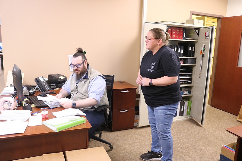 City Clerk Shannon Romano speaks with Purchasing Agent Paul Baldini Jr. while working at City Hall on Saturday.