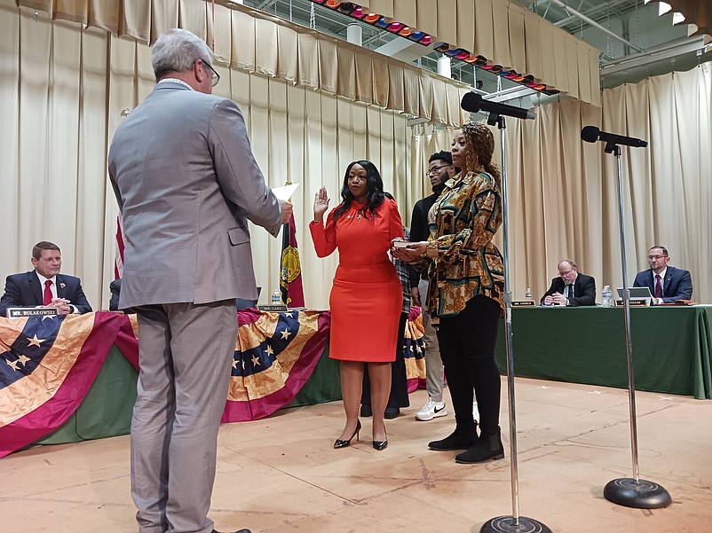 Commissioner Melanie Collette, in red dress, is sworn in by former Middle Township Mayor Timothy Donohue, while accompanied by her sister, Anika Collette, and nephew, Jalen Freeman.