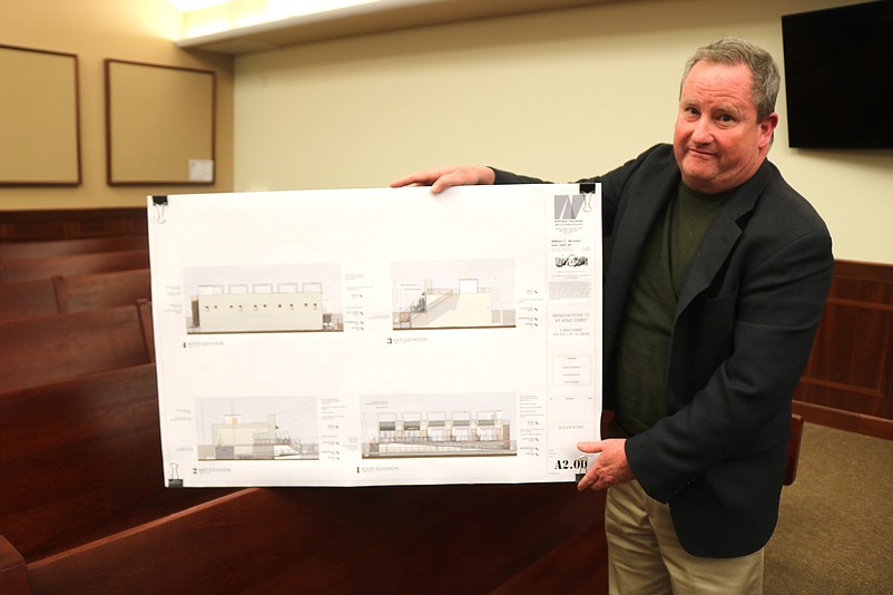 Architect William McLees shows a rendering of the building's proposed upscale facade.