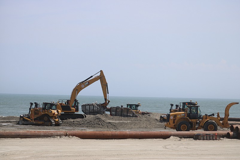 Construction crews spread new sand on the beach at 82nd Street.