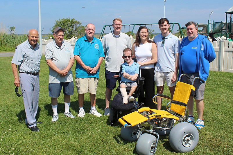 Dylan Breen, seated, is joined by family members and Sea Isle City officials during his donation of the pediatric beach wheelchair. (Photo courtesy of Sea Isle City)