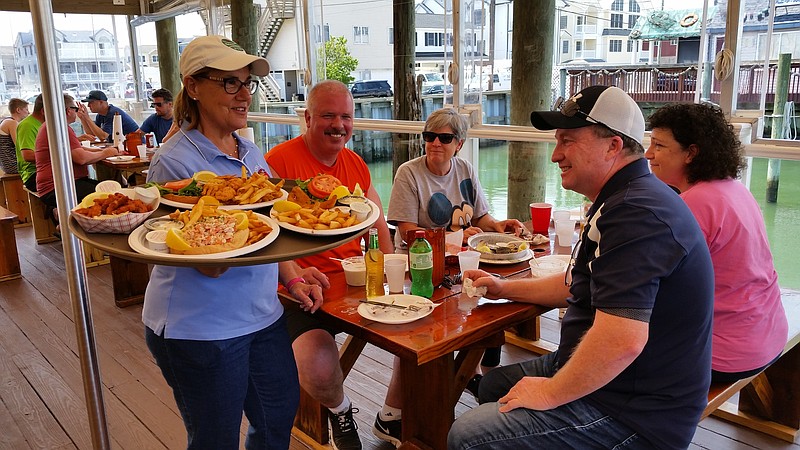 Rosemary Deery serves up a food platter to customers at Mike's Seafood and Dock Restaurant.