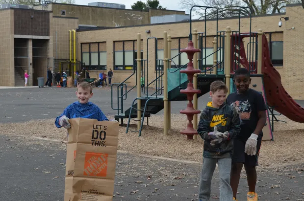 North Wales Elementary School students clean up leaves and debris near the school playground for Earth Day in 2017. (Photo courtesy of North Penn School District)