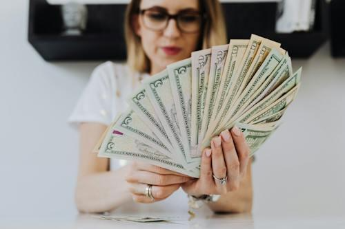 Free Woman Holding Fan of Us Dollar Bills Stock Photo