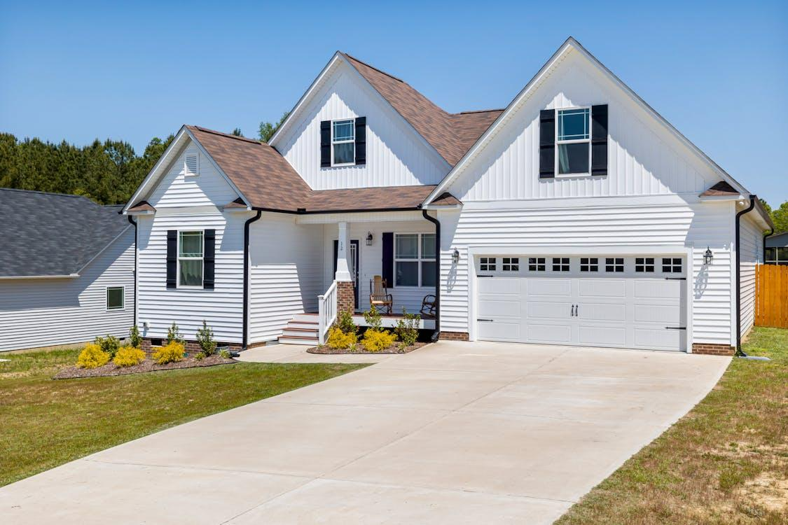 Free Elegant modern suburban home with garage and landscaped garden in daylight. Stock Photo