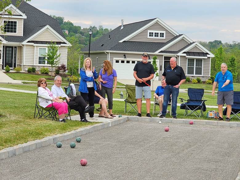 A group of people playing bocce

Description automatically generated