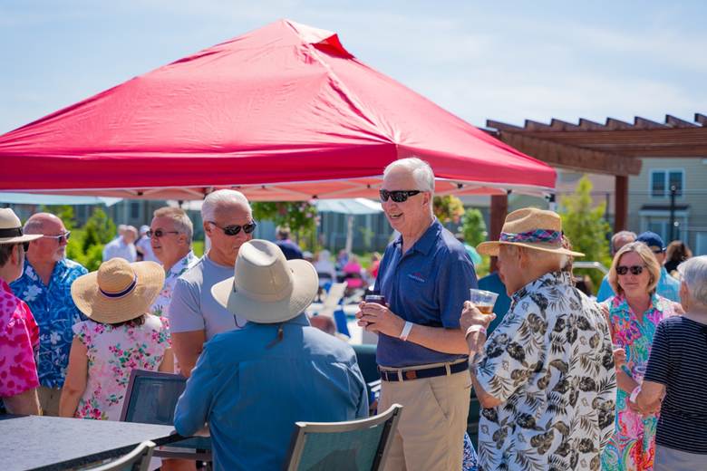 A group of people standing under a tent

Description automatically generated