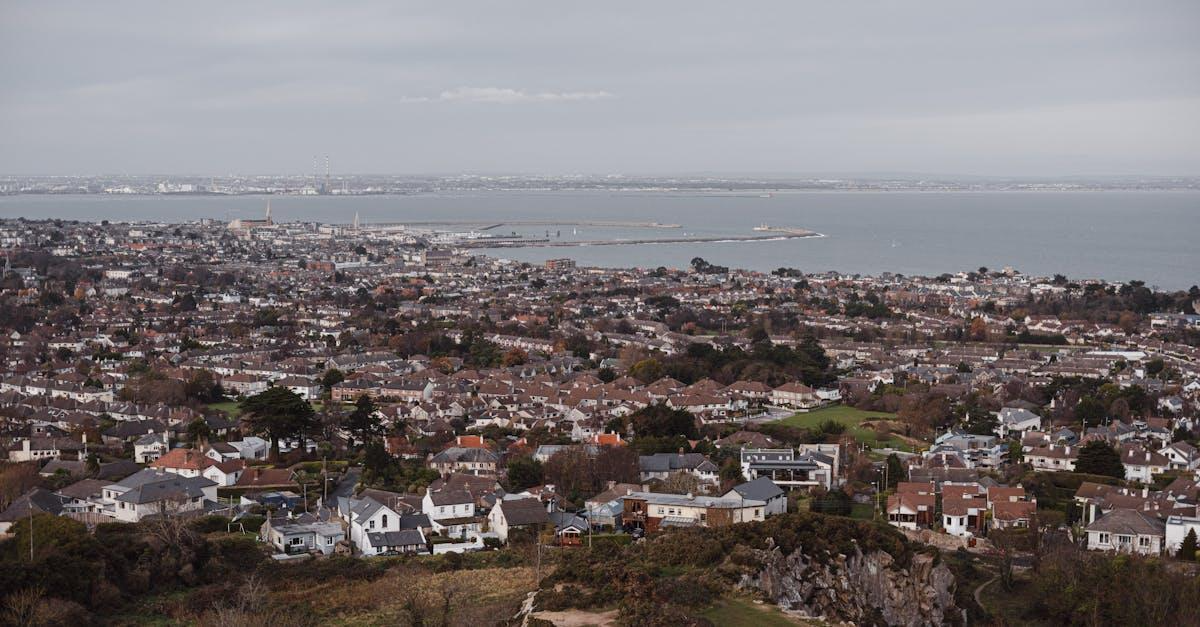Scenic aerial shot of a coastal town in Ireland, capturing urban landscape with ocean backdrop.