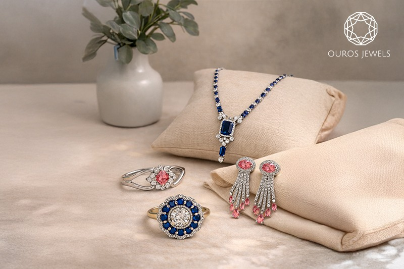 Lab grown diamond jewelry set with gemstone necklace, rings, and drop earrings displayed on cushions