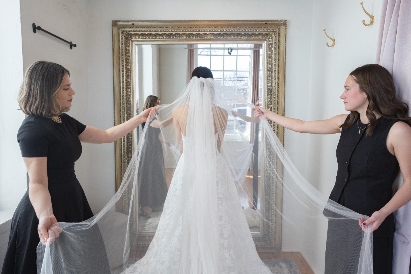 Owner Madison and Stylist McKay helping a bride in a luxurious and private fitting room.