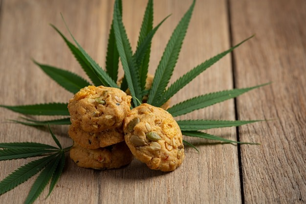 cannabis cookies and cannabis leaves put on wooden floor