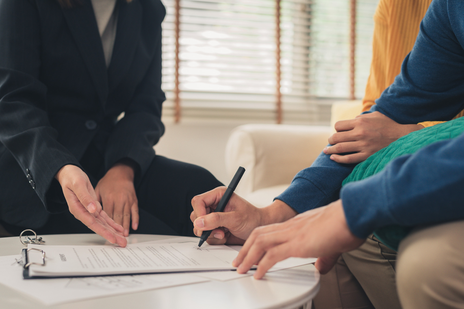 A group of people sitting around a table signing a document

AI-generated content may be incorrect.