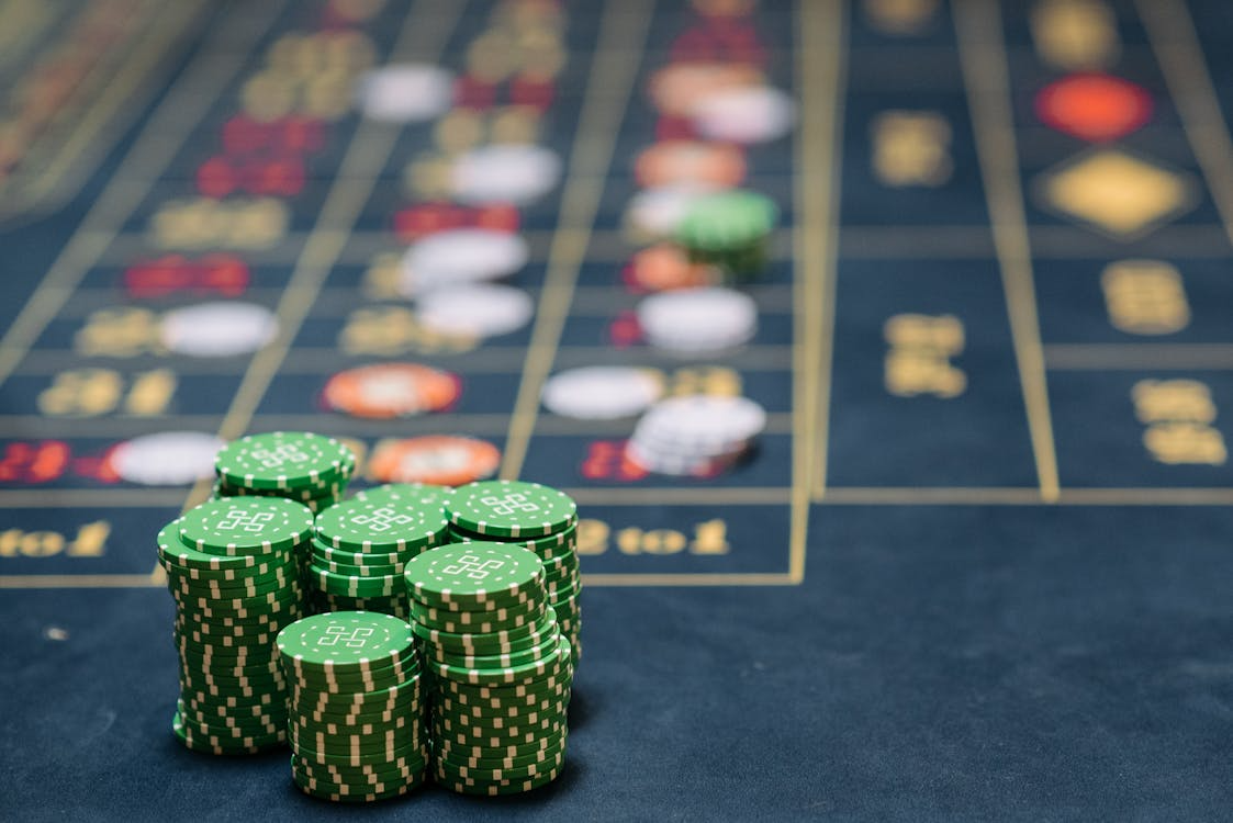 A pile of green poker chips on a black table

AI-generated content may be incorrect.
