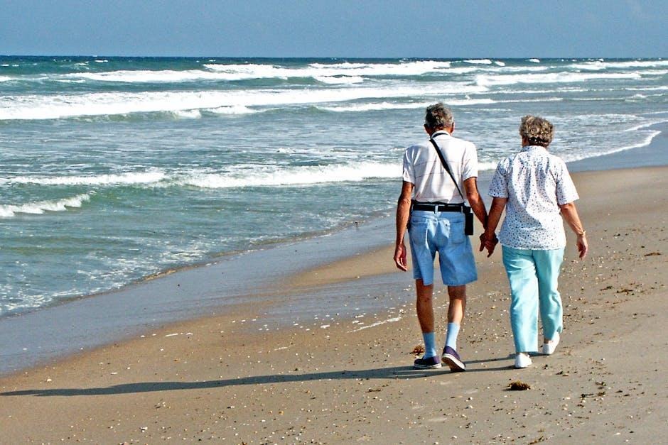 A senior couple walking together on a shore boardwalk