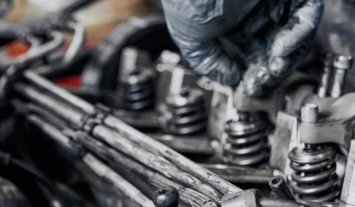 Mechanic in gloves inspecting internal car engine valve springs