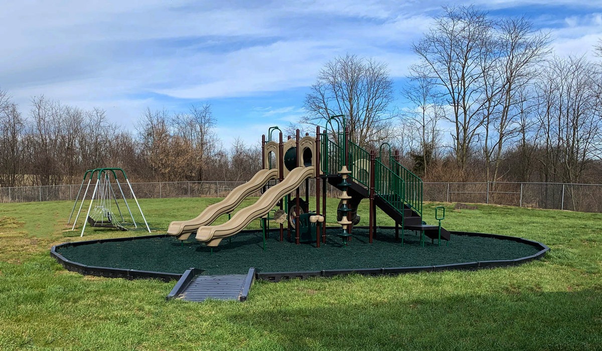 Modern outdoor playground structure with slides and a swing set 