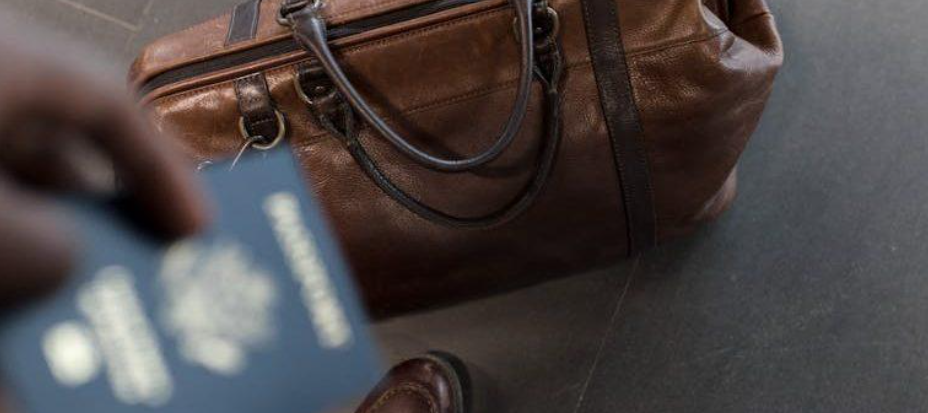 a man holding a passport, ready to move abroad from New Jersey